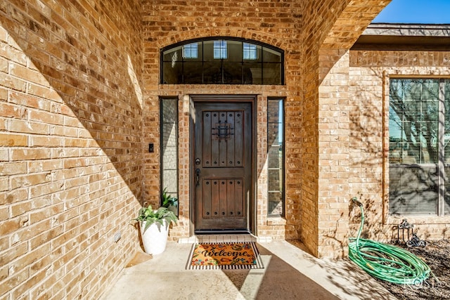 doorway to property with brick siding