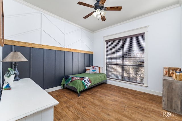 bedroom with crown molding, wood finished floors, and ceiling fan