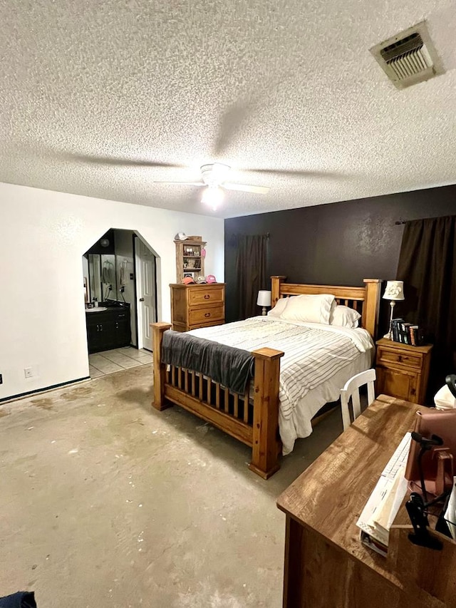 bedroom featuring arched walkways, a textured ceiling, visible vents, and unfinished concrete floors