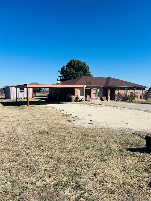 view of front facade featuring a front lawn and a carport