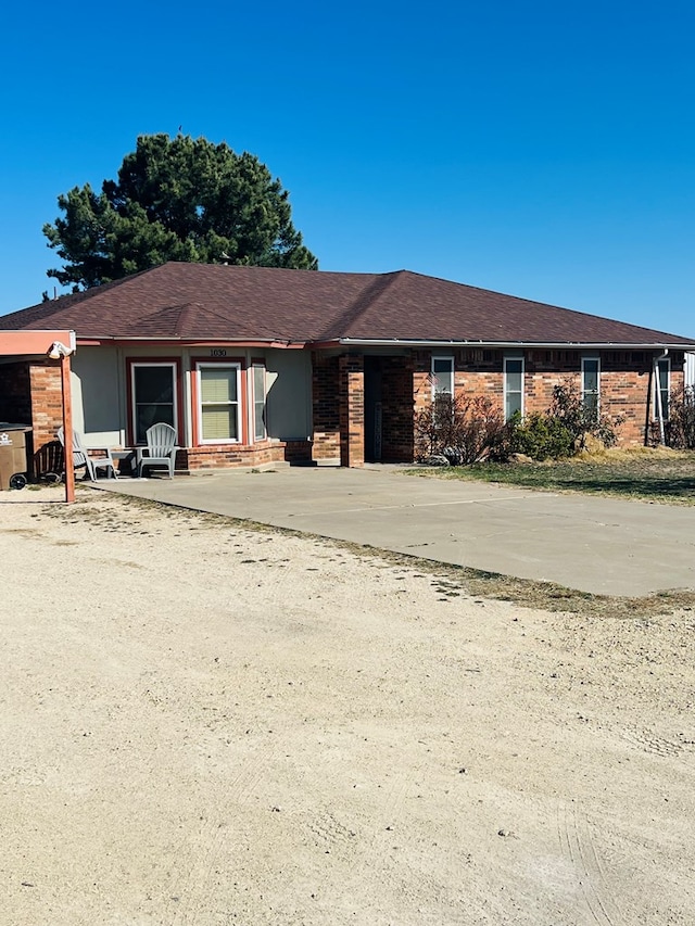 single story home with brick siding and roof with shingles