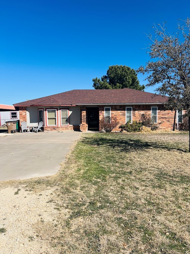 single story home featuring brick siding and a front lawn