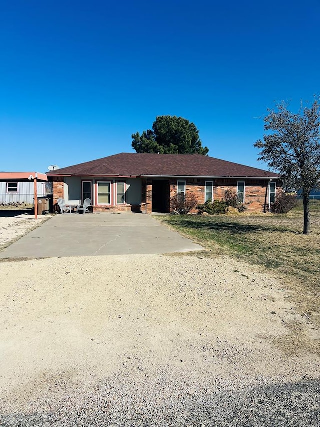 ranch-style house featuring brick siding and driveway