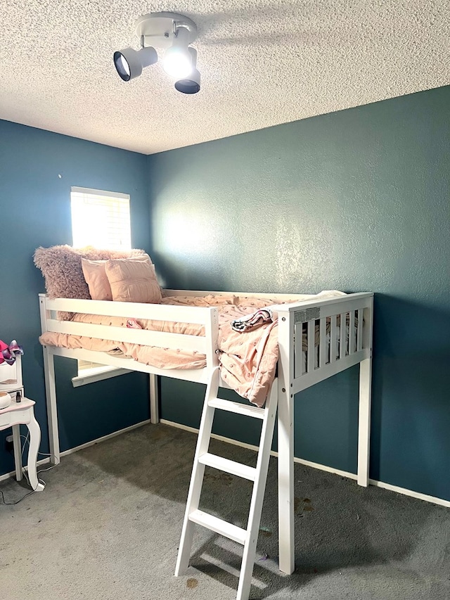 unfurnished bedroom with a textured ceiling and carpet floors