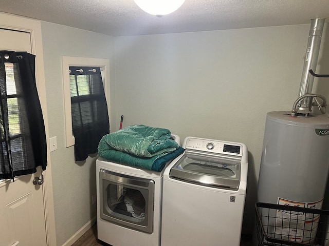 laundry area with gas water heater, a textured ceiling, and independent washer and dryer