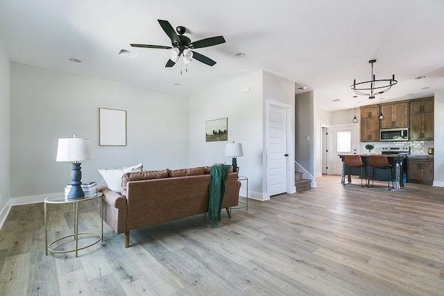 living room featuring ceiling fan and light hardwood / wood-style flooring