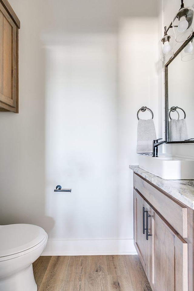 bathroom with vanity, hardwood / wood-style flooring, and toilet