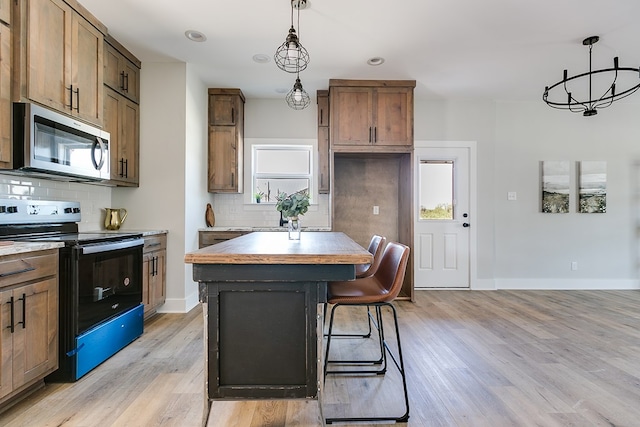 kitchen with tasteful backsplash, a kitchen island, electric range oven, and light wood-type flooring