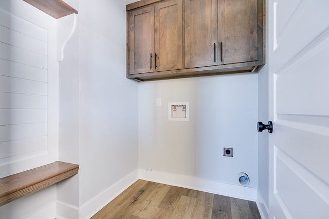 laundry room featuring cabinets, electric dryer hookup, washer hookup, and light wood-type flooring