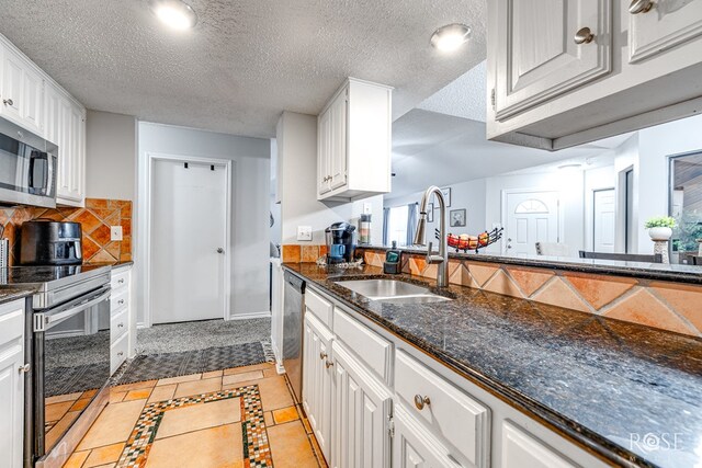 kitchen with white cabinetry, appliances with stainless steel finishes, sink, and tasteful backsplash