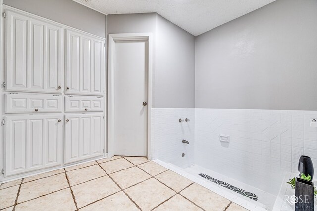 bathroom featuring tile patterned floors and a textured ceiling