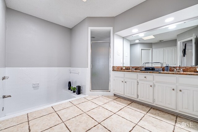 bathroom featuring vanity, tile patterned floors, and walk in shower