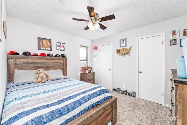 carpeted bedroom with ceiling fan and a textured ceiling