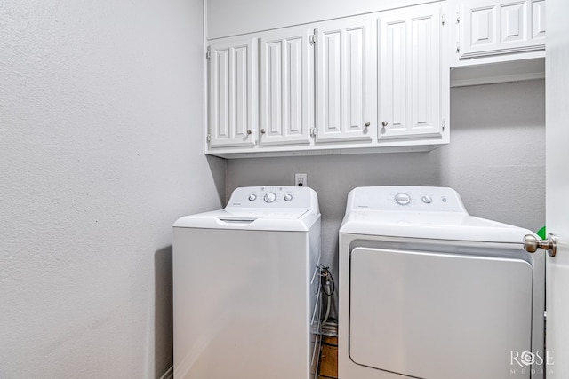 clothes washing area featuring cabinets and independent washer and dryer