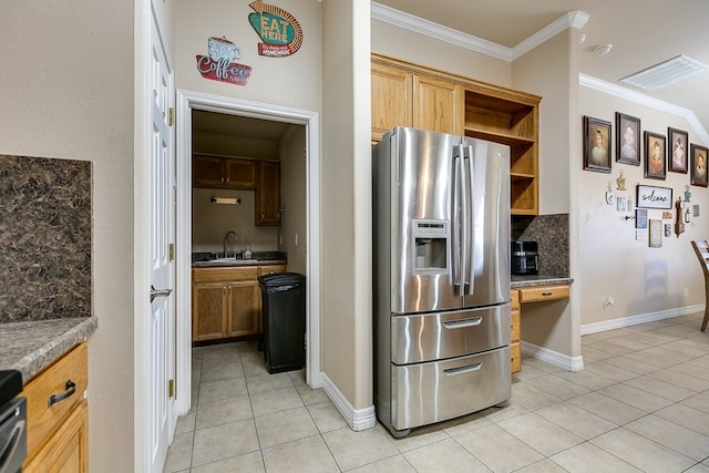 kitchen featuring a sink, light tile patterned flooring, ornamental molding, and stainless steel refrigerator with ice dispenser