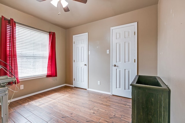 bedroom with baseboards, wood finished floors, and a ceiling fan