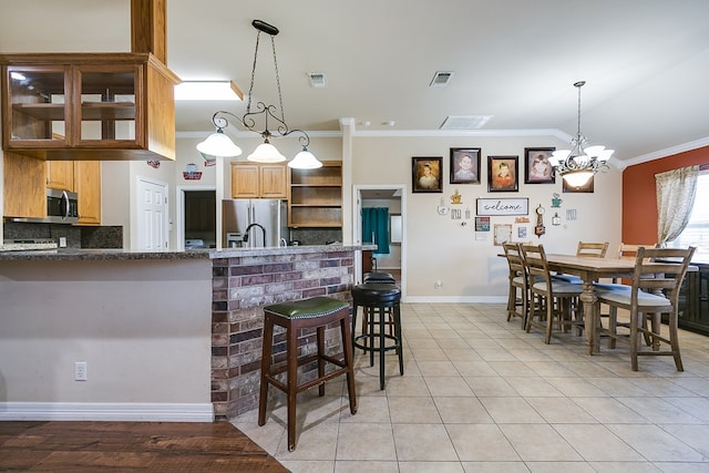 kitchen with visible vents, light tile patterned flooring, stainless steel appliances, crown molding, and backsplash