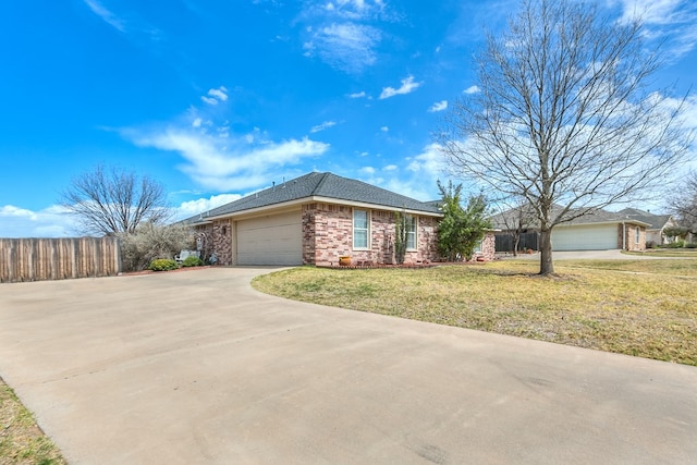 ranch-style home featuring driveway, fence, a front yard, a garage, and brick siding