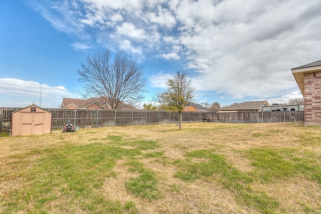 view of yard featuring a storage unit, an outbuilding, and a fenced backyard