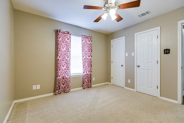 unfurnished bedroom featuring carpet flooring, baseboards, visible vents, and ceiling fan