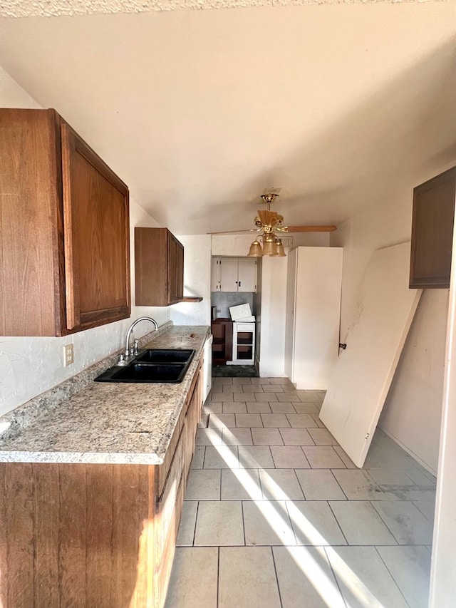 kitchen with ceiling fan, sink, and light tile patterned floors