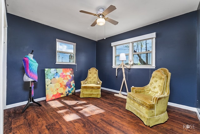 living area featuring ceiling fan and dark hardwood / wood-style flooring