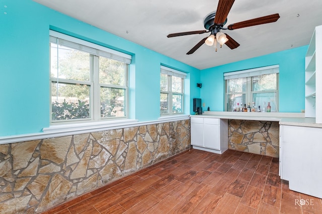 interior space with white cabinetry and ceiling fan