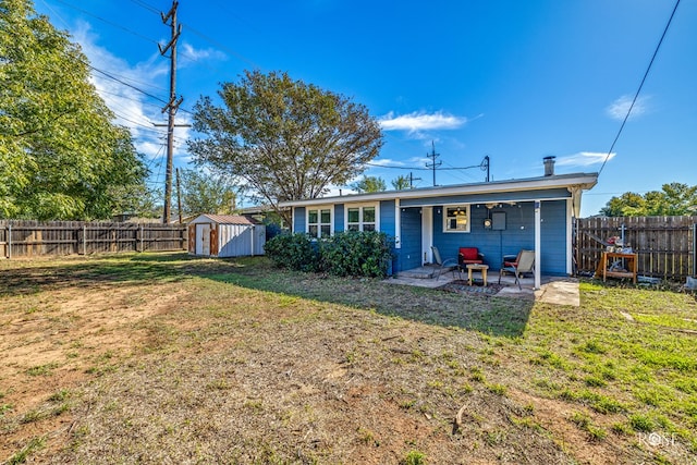 rear view of house with a storage unit, a patio, and a lawn