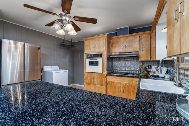 kitchen featuring washer / clothes dryer, sink, stainless steel fridge, black electric stovetop, and white oven