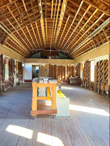 miscellaneous room with hardwood / wood-style flooring, vaulted ceiling, and brick ceiling