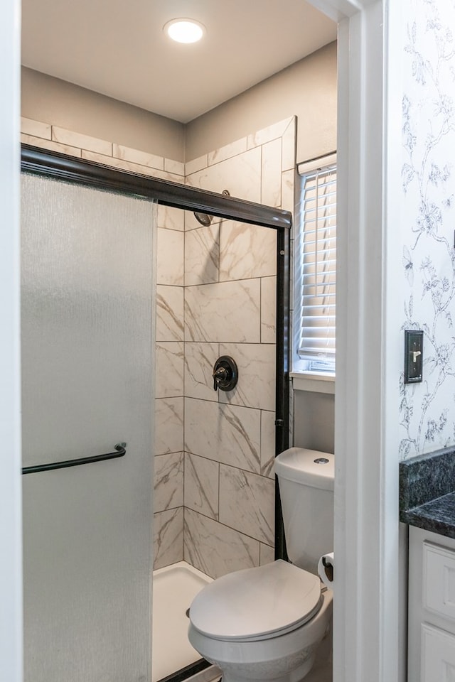 bathroom featuring toilet and an enclosed shower