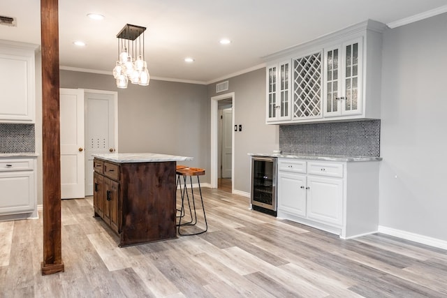 kitchen with white cabinetry, wine cooler, and pendant lighting