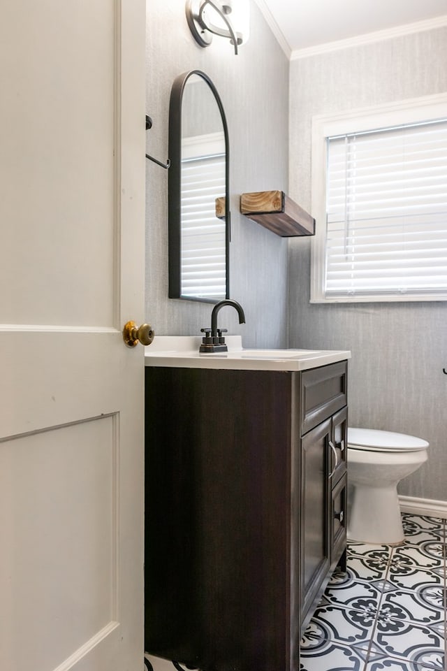 bathroom with toilet, tile patterned floors, vanity, and ornamental molding