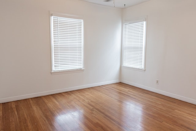 empty room with ceiling fan, crown molding, and wood-type flooring