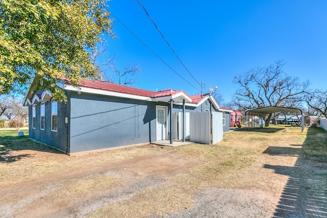 view of property exterior with a carport and a yard