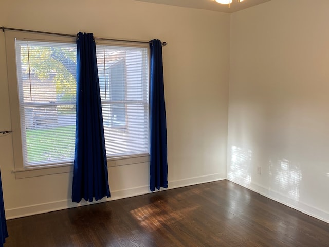 spare room with dark wood-type flooring