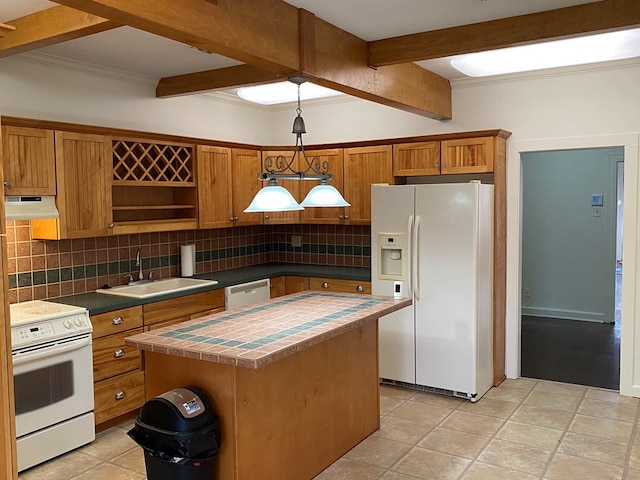 kitchen featuring sink, white appliances, hanging light fixtures, a kitchen island, and decorative backsplash