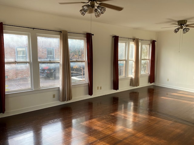 spare room featuring plenty of natural light and dark wood-type flooring