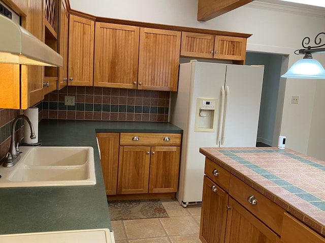 kitchen featuring decorative light fixtures, sink, decorative backsplash, and white fridge with ice dispenser