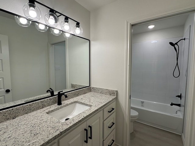 bathroom featuring toilet, washtub / shower combination, wood finished floors, and vanity