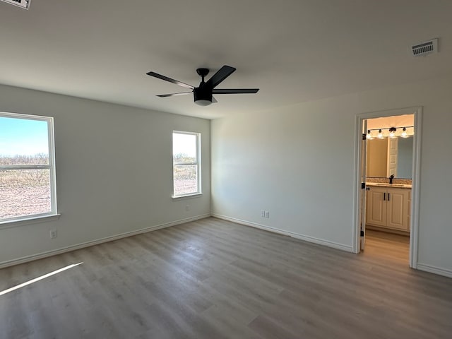 unfurnished bedroom featuring light wood-style floors, baseboards, visible vents, and a ceiling fan