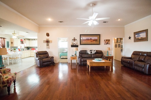 living area featuring dark wood-style floors, ornamental molding, and visible vents