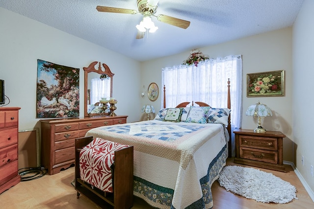 1027 Butterfly Ln, San Angelo, TX 76905 - bedroom featuring a ceiling fan, a textured ceiling, and light wood-type flooring