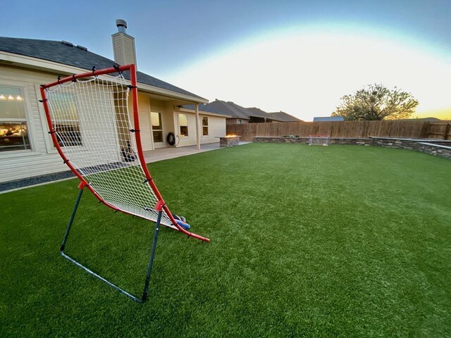 yard at dusk featuring a patio area