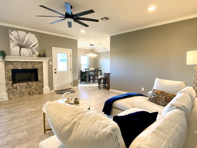 living room featuring a fireplace, ornamental molding, ceiling fan, and light wood-type flooring