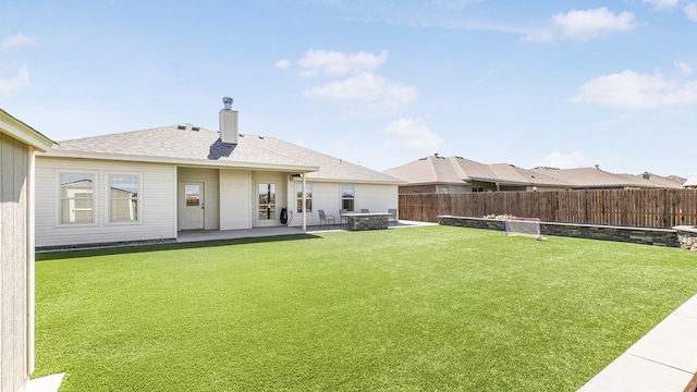 back of house featuring a lawn and a patio