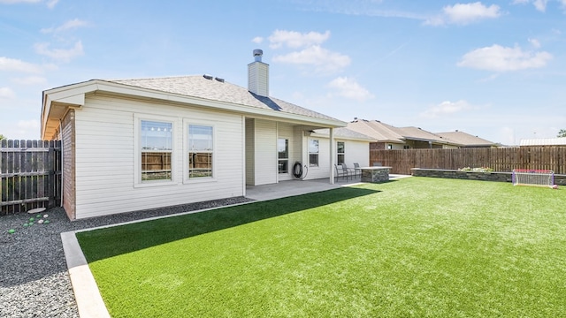 rear view of property featuring a lawn and a patio area