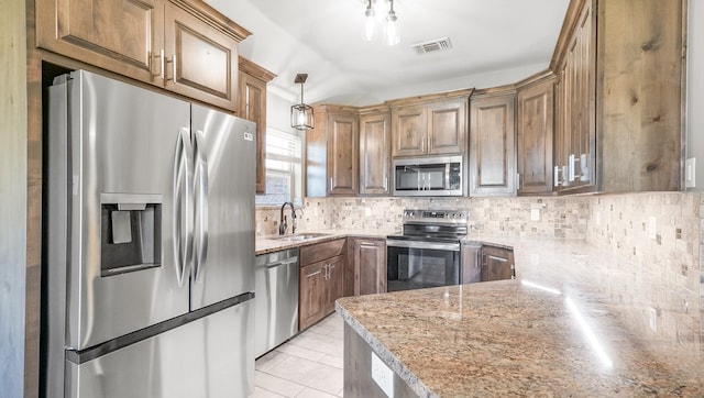 kitchen featuring pendant lighting, sink, decorative backsplash, and appliances with stainless steel finishes