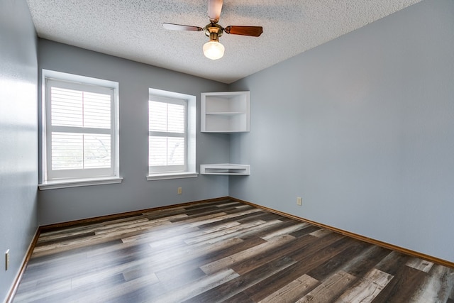 unfurnished room with lofted ceiling, ceiling fan, dark wood-type flooring, and a textured ceiling