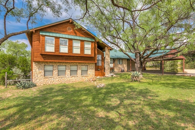 rear view of property featuring a carport and a lawn